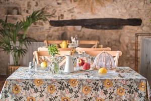 a table with a table cloth with fruit on it at Menta Rural in San Pedro Sallavinera