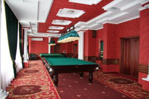 a pool table in a room with red walls at SPA-Hotel SINDICA in Nalchik