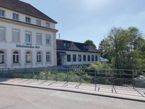 un bâtiment avec une clôture devant lui dans l'établissement Hotel Waibstadter Hof, à Waibstadt