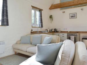 a living room with a couch and a kitchen at The Hay Barn in Barnby