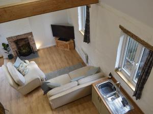 an overhead view of a living room with a couch and a tv at The Hay Barn in Barnby