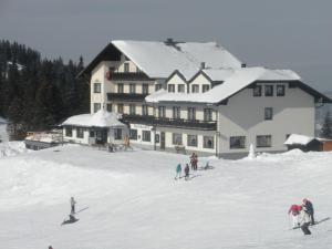 a group of people skiing in the snow in front of a building at Hochkarhof in Göstling an der Ybbs
