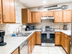 a kitchen with wooden cabinets and a stove top oven at Beach Happy-Lake Close-Private Waterpark Oasis -sleeps 14 in Lake Havasu City