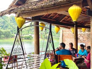 un gruppo di persone seduti a un tavolo in un ristorante di Phong Nha Coco House a Phong Nha