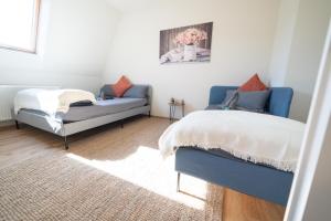 um quarto com uma cama azul e um sofá em FULL HOUSE Studios - The Buffalo Apartment - WiFi em Zwickau