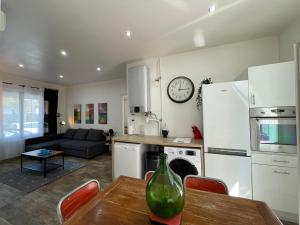 eine Küche und ein Wohnzimmer mit einem Tisch und einem Kühlschrank in der Unterkunft La Seyne sur mer grande terrasse wifi clim, 2 chambres in La Seyne-sur-Mer