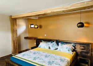 a bedroom with a bed with a wooden headboard at The Forest Resort - Lweza in Makindye