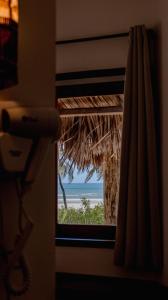 una ventana en una habitación con vistas al océano en Villa Kabaceiras en Tatajuba