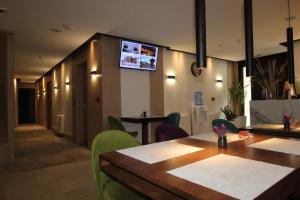 Hotel Boss في سراييفو: مطعم به طاولات وكراسي وتلفزيون على الحائط