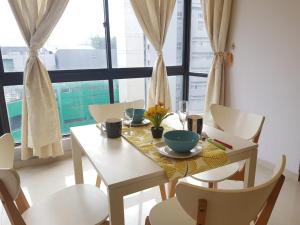 stół jadalny z krzesłami, stół i okno w obiekcie Bukit Bintang Fahrenheit88 Apartment by Sarah's Lodge w Kuala Lumpur