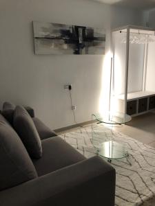 sala de estar con sofá y mesa de cristal en VEROMA PISOS, en Granada