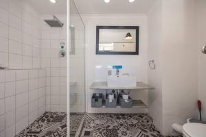 a bathroom with a shower with a sink and a mirror at Homely Studio Apartment in Cape Town in Cape Town