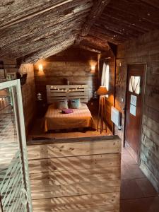 a bedroom with a bed in a wooden cabin at Chambre avec spa privé in Candor