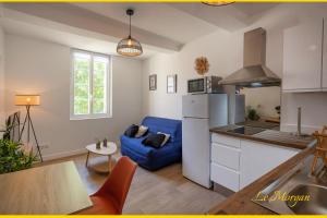 una cucina e un soggiorno con divano blu di Le Morgan - Magnifique appartement cours principal plein centre avec parking a Salon-de-Provence