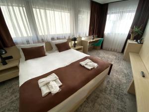 um quarto de hotel com uma cama grande com toalhas em Hotel Boss em Saraievo