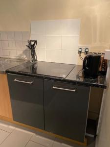 a kitchen with a black counter top with a sink at The Grange in Bristol