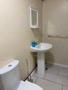 a white bathroom with a toilet and a sink at The Grange in Bristol