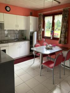 a kitchen with a table and chairs in a room at Maison Catharina in Vielsalm +13 photos