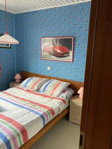 a bedroom with a bed with a picture of a car on the wall at Maison Catharina in Vielsalm