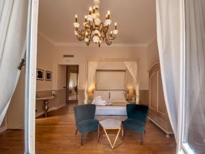 サンタ・マルゲリータ・リグレにあるHotel Sant'Andreaのベッド1台、椅子2脚、シャンデリアが備わる客室です。