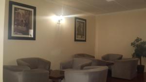 ein Wartezimmer mit Stühlen und einer Lampe an der Wand in der Unterkunft Victoria Hotel in Bredasdorp