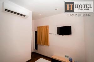 a room with a flat screen tv on a wall at H Hotel in Segamat