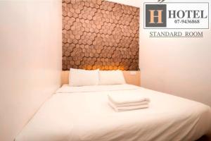 a hotel room with a bed with towels on it at H Hotel in Segamat