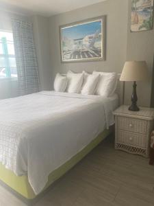 a bedroom with a bed and a lamp on the wall at Hideaway Village in Fort Myers Beach