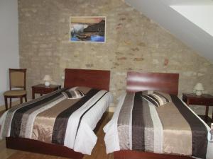 two beds in a hotel room with two bedsvisor at Chambre d'hotes "Les Bordes" in Marzy