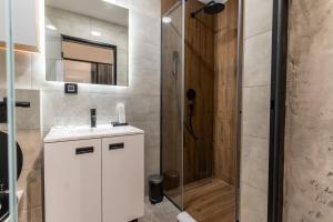 a bathroom with a shower and a sink and a mirror at Silver Luxury Suites in Belgrade
