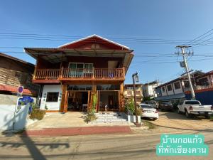 a building with a balcony on the side of a street at Baan Kokaew Chiang Khan in Chiang Khan