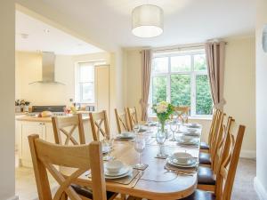 a dining room with a table with chairs and a kitchen at Renchers Farmhouse in Crossway Green