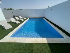 - une piscine dans une maison avec des chaises et de la pelouse dans l'établissement Alojamiento Rural Buenavista, à Arcos de la Frontera