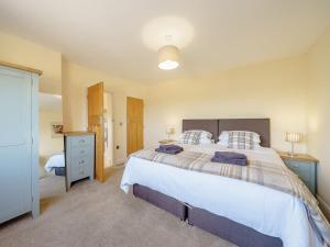 a bedroom with a large bed with two pillows at Renchers Farmhouse in Crossway Green