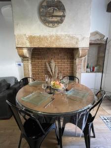 a dining room table with chairs and a fireplace at Le Petit Duc in Dijon