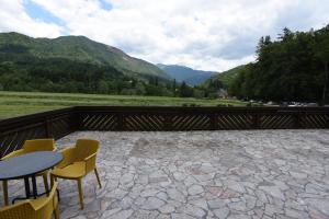 a patio with a table and chairs and mountains at LakeView Apartment in Preddvor