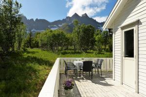un patio con mesa y sillas en una terraza en Cozy Apartment between sea and mountains en Mefjordvær