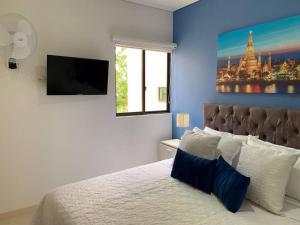 a bedroom with a large bed with a blue wall at G307Espectacular Apartamento, Condominio Campestre in La Tebaida