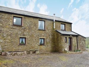 a stone house with windows on the side of it at Belah Barn in Kirkby Stephen