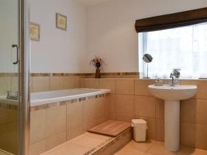 a bathroom with a bath tub and a sink at Belah Barn in Kirkby Stephen