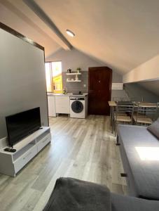 een woonkamer met een bank en een tv en een keuken bij Acojedor Apartamento en Bermeo in Bermeo