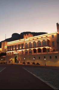 a large building with a mountain in the background at SARA RIVIERA Costa Plana in Cap d'Ail