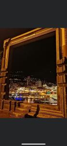 a window with a view of a city at night at SARA RIVIERA Costa Plana in Cap d'Ail