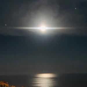 a full moon rising over the ocean at night at SARA RIVIERA Costa Plana in Cap d'Ail