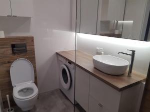 y baño con aseo blanco y lavamanos. en NEW APARTMENT Wołyńska - przestronny, z widokiem, czysto, parking, balkon, en Rzeszów