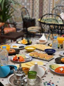 uma mesa coberta com pratos de alimentos e bebidas em Dar Rehab em Rabat
