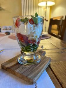 a glass vase filled with food on a wooden table at B&B La Casa Del Riccio in Cinto Euganeo