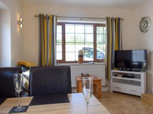 a living room with a table with two wine glasses on it at Windhover in Glasbury