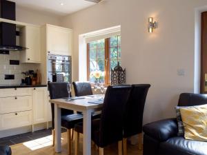 a kitchen with a dining room table and chairs at Windhover in Glasbury
