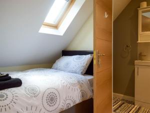 a bedroom with a white bed and a window at Windhover in Glasbury